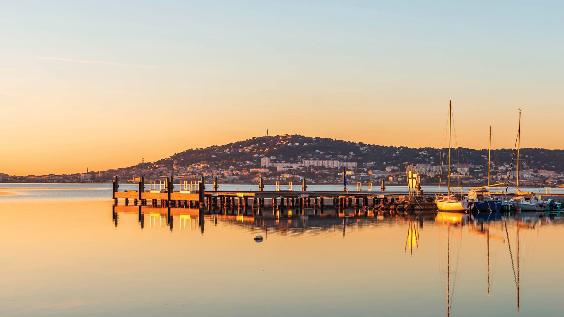 Ponton sur l'étang de Thau, vue sur Sète au coucher de soleil